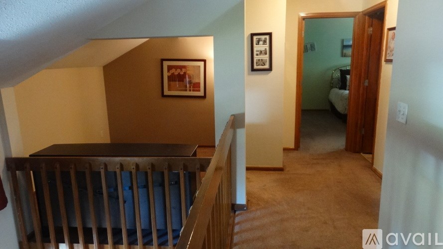 A room with a wooden staircase and a painting on the wall.