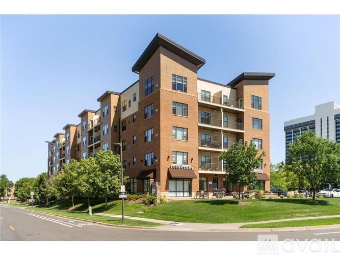A large apartment building with a grassy front yard.