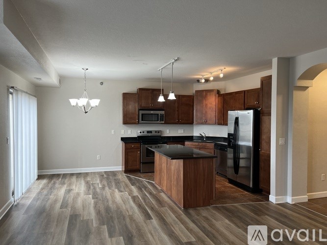 A kitchen with a refrigerator, microwave, and oven.