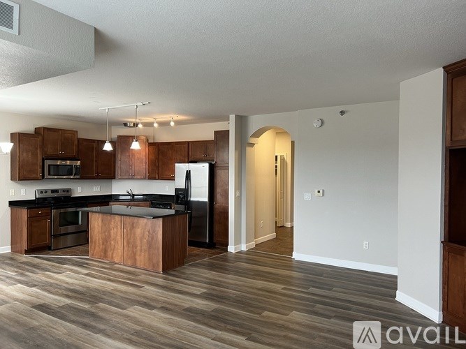 A modern kitchen with dark wood floors and a white ceiling.