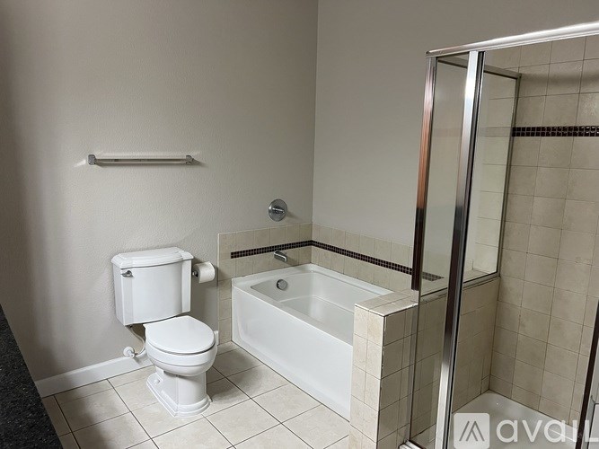 A white toilet sits next to a white bathtub in a bathroom.