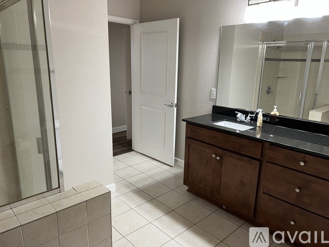 A bathroom with a sink, mirror, and a white door.