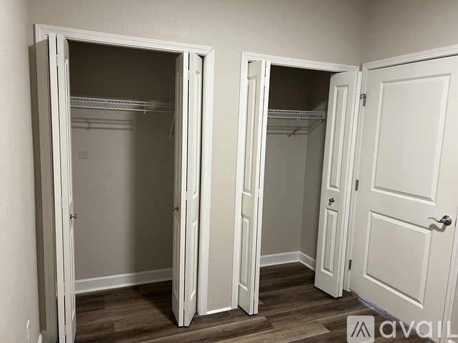A white closet with two open doors and shelves.