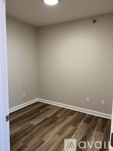 A room with wooden flooring and white walls.