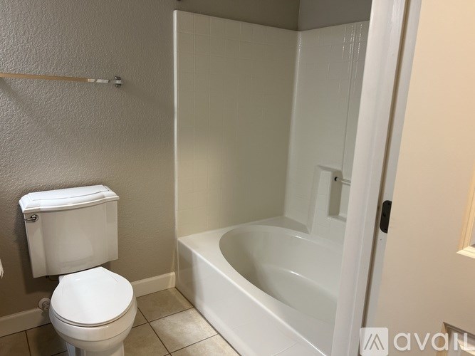 A white toilet and bathtub in a bathroom.