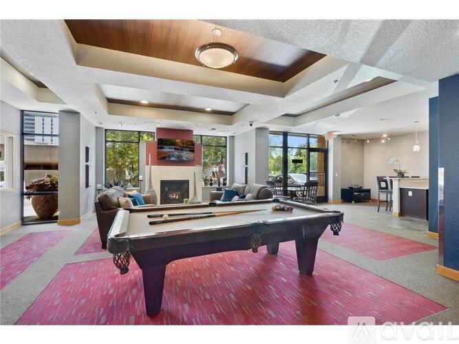A pool table is in the middle of a room with a fireplace and a TV.