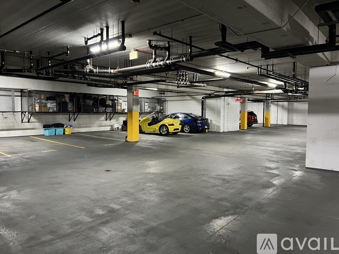 A yellow car is parked in a large, empty garage.
