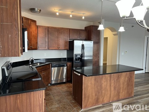 A kitchen with wooden cabinets and a black countertop.