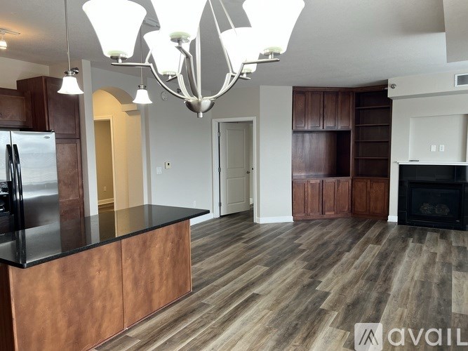 A modern kitchen with a wooden island and a black fridge.
