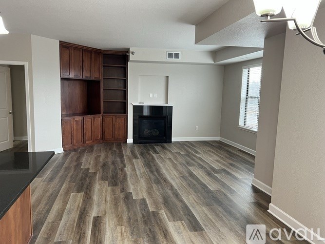 A living room with a fireplace and wood flooring.