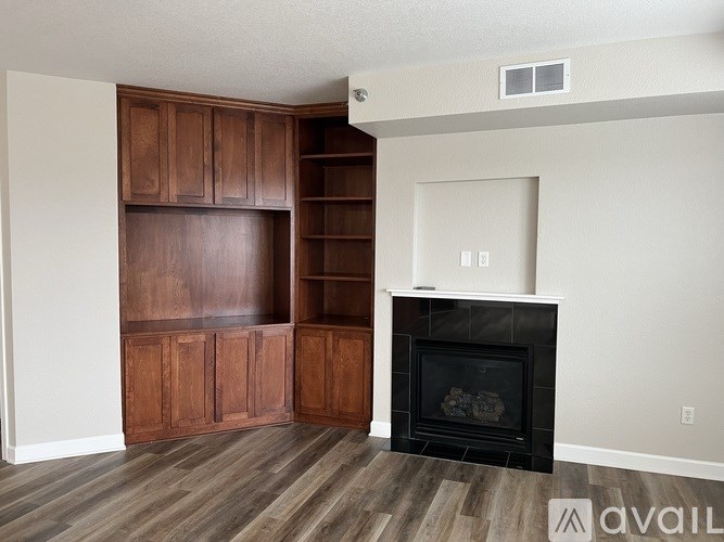 A living room with a fireplace and wooden floors.