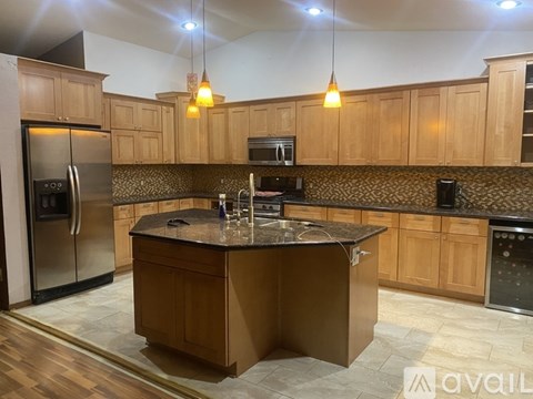 A kitchen with wooden cabinets and a central island.