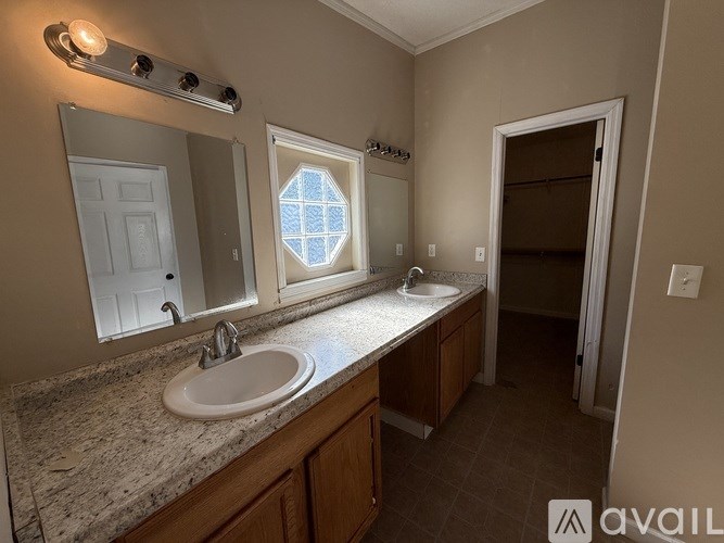 A bathroom with a sink, mirror, and shower.