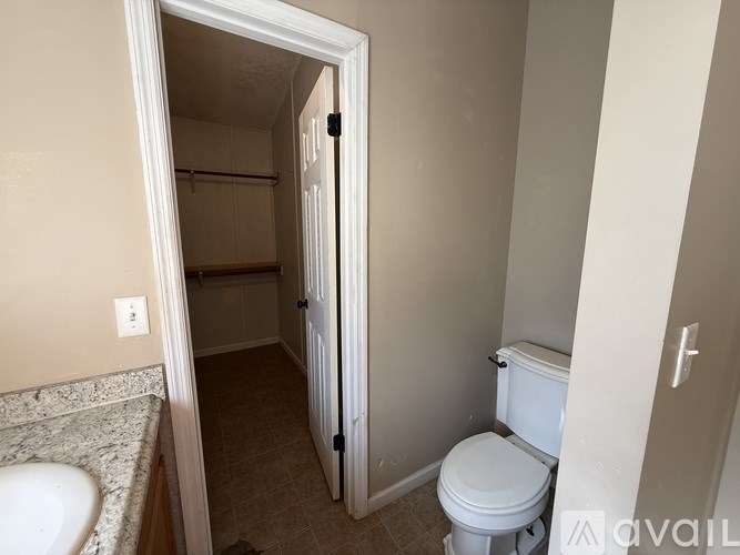 A bathroom with a toilet, sink, and a mirror.