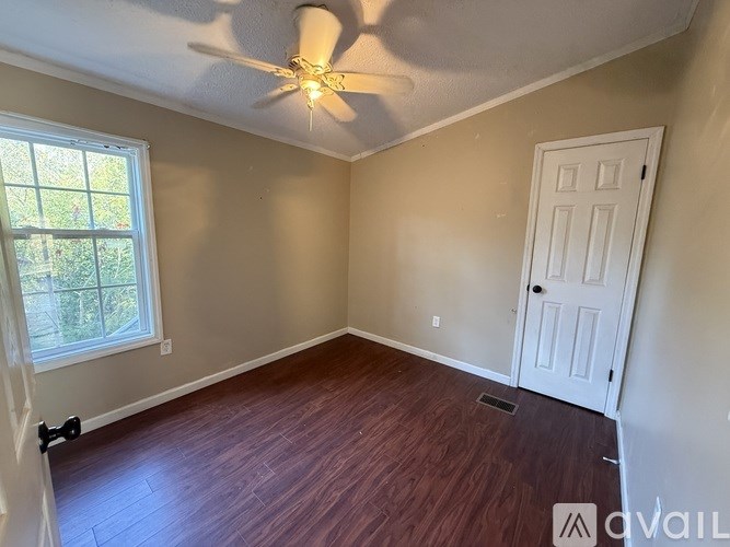 A room with a ceiling fan and a door.