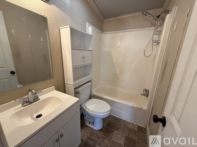 A bathroom with a toilet, sink, and bathtub.