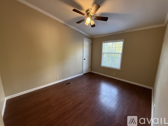 A room with a ceiling fan and wooden flooring.