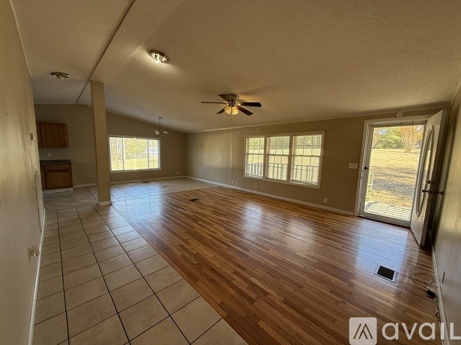 A spacious room with wooden flooring and a ceiling fan.