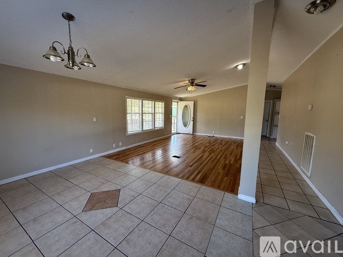 A spacious room with a fan and a light fixture on the ceiling.