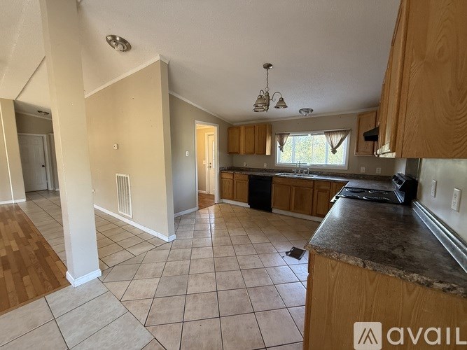 A kitchen with wooden cabinets and a tiled floor.