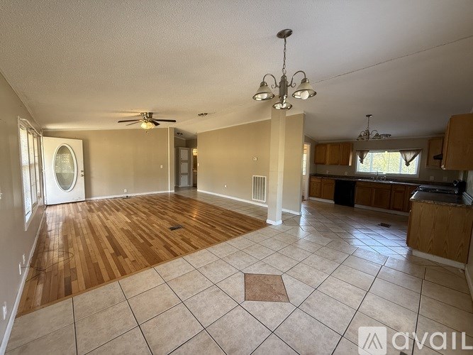 A spacious room with wooden flooring and a ceiling fan.