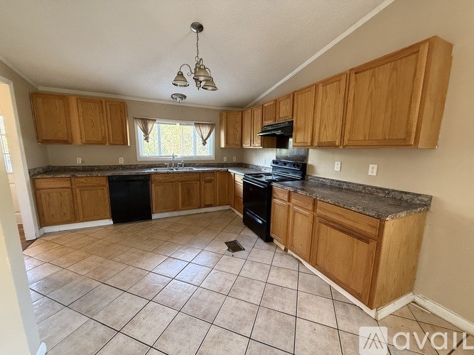 A kitchen with wooden cabinets and black appliances.
