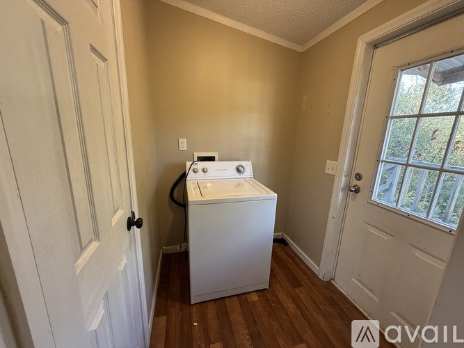 A small room with a washing machine and a window.