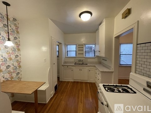 A kitchen with a wooden table and white cabinets.