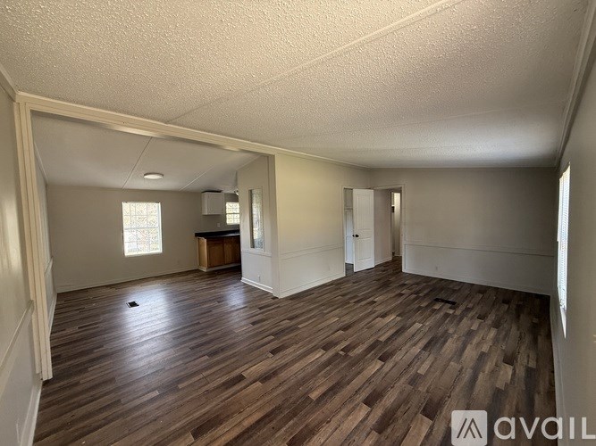 A room with wooden flooring and white walls.