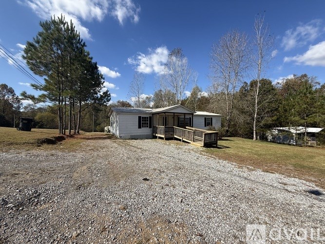 A house with a gravel driveway in front of it.