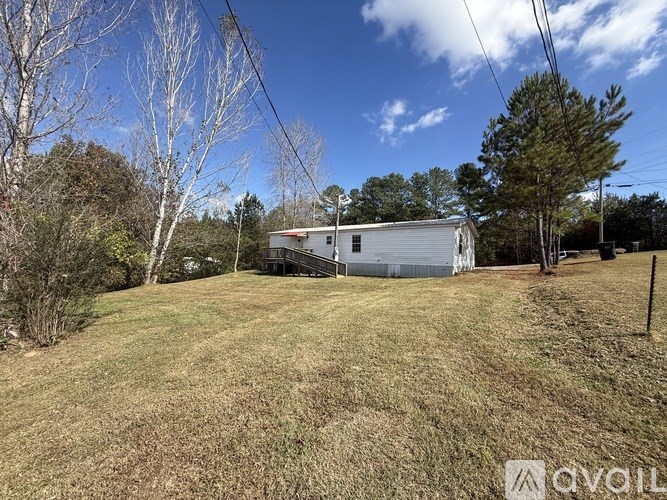 A house is situated in a grassy area with trees around it.