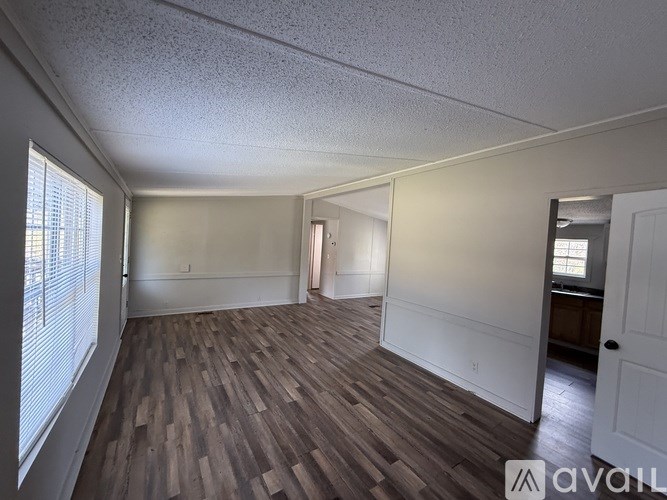 A room with wooden flooring and white walls.