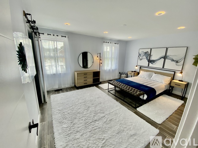 A bedroom with a large bed and a mirror on the wall.