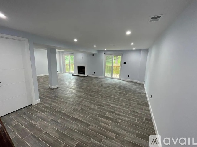 A spacious room with a grey floor and white walls.