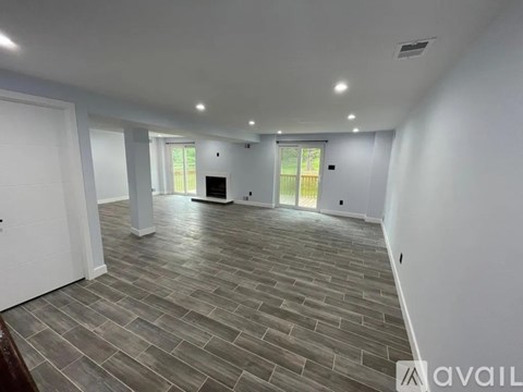 A spacious room with a grey floor and white walls.