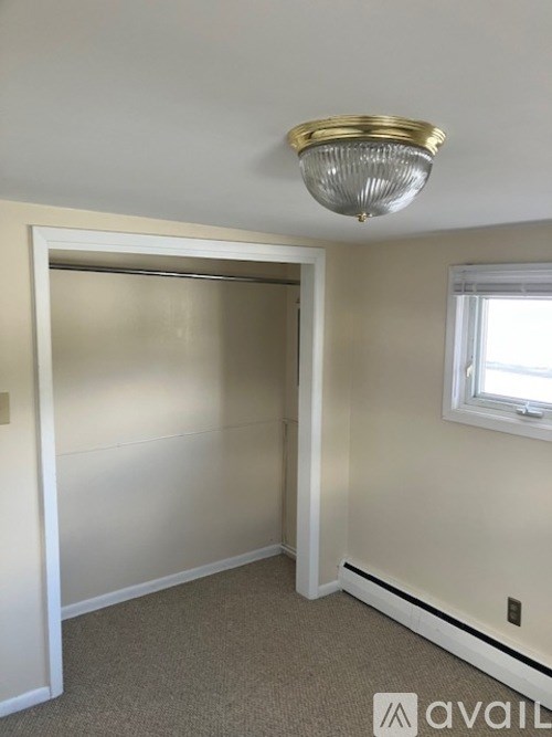 A room with a carpeted floor and a window.