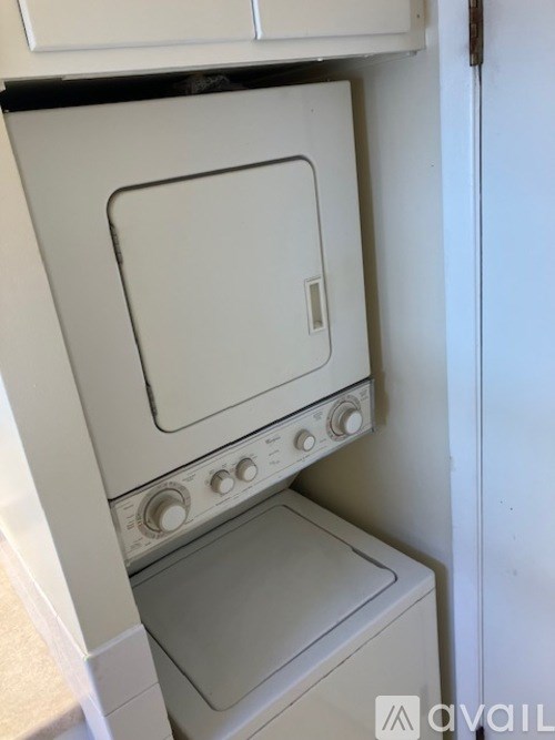 A white oven with a door and knobs is in a kitchen.