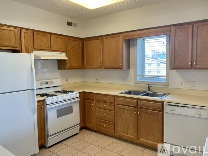 A kitchen with wooden cabinets and white appliances.