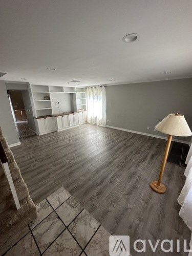 A room with a lamp and wooden flooring.