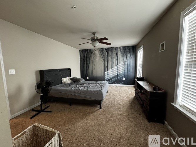 A bedroom with a bed, dresser, and window.