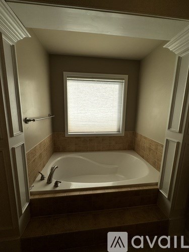 A bathroom with a tub and a window.