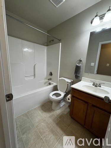 A bathroom with a toilet, sink, and bathtub.