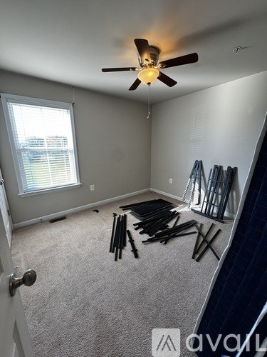 A room with a ceiling fan and a window with blinds.