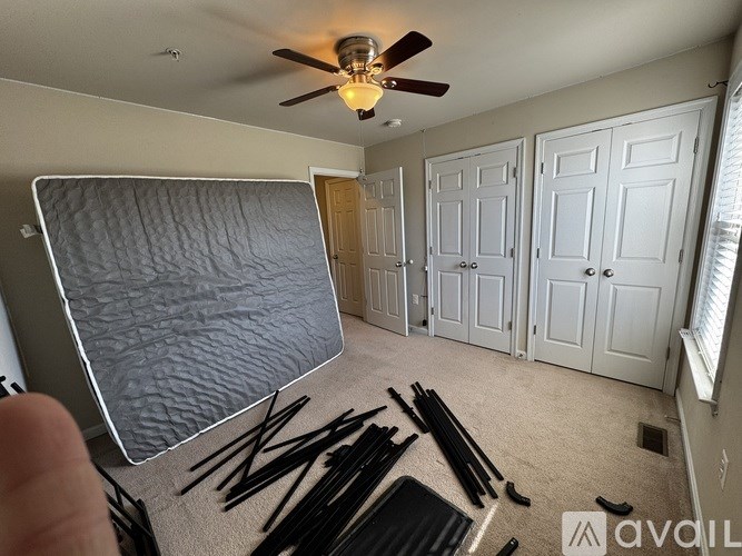 A room with a ceiling fan and a wall with a window.