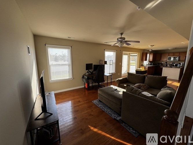 A living room with a brown couch and a television on a stand.