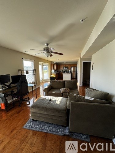 A living room with a couch, chair, and television.