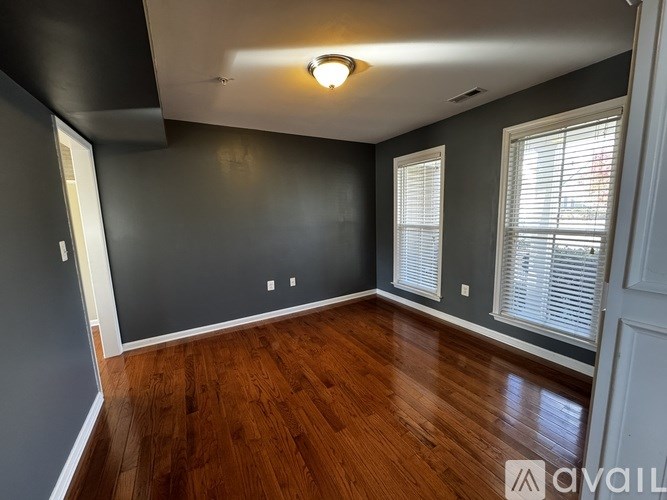 A room with wooden floors and grey walls.