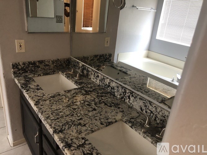 A bathroom with a marble countertop and a large mirror.