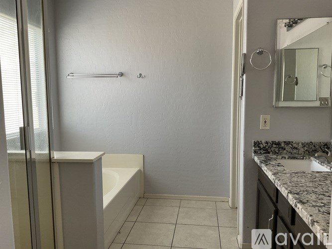 A bathroom with a white tub and a marble counter.