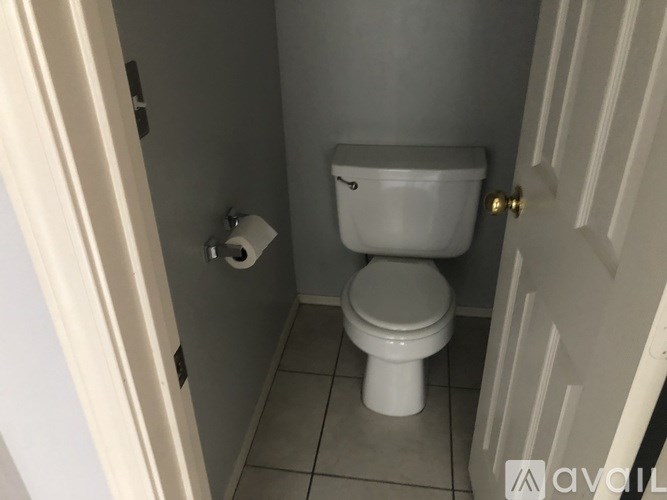 A white toilet in a small bathroom with a white door.